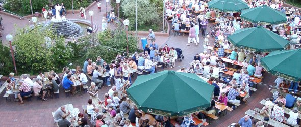 Blick von oben auf die Mutterstadter Zeltkerwe mit Bierzelt und Sitzgarnituren um den Brunnen auf dem Herbert-Maurer-Platz