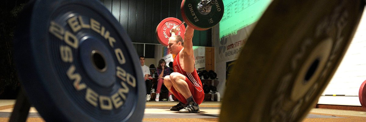 Gewichtheber in Aktion Blick durch zwei Gewichtsscheiben auf einen Gewichtheber des AC Mutterstadt in Aktion