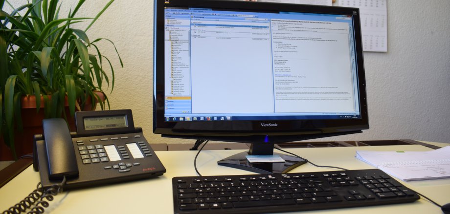 Abbildung eines Arbeitsplatzes im Büro mit Telefon und Computer